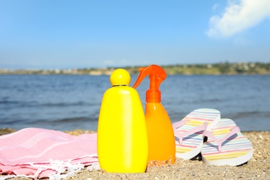 Composition with bottles of sun protection body cream on beach, space for design