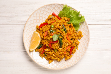 Photo of Delicious rice pilaf with vegetables on white wooden table, top view