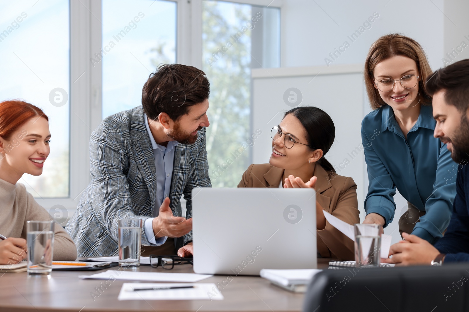 Photo of Team of employees working together in office