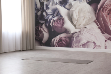 Photo of Grey yoga mat on floor in spacious room