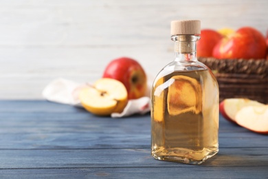 Photo of Composition with bottle of apple vinegar on table. Space for text