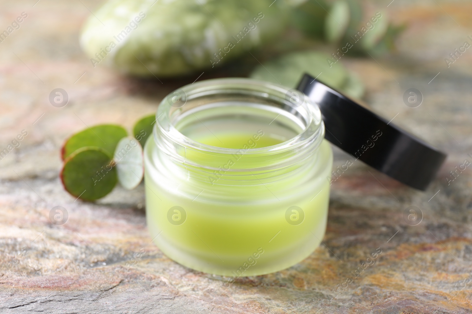 Photo of Jar of cream on textured table, closeup. Body care product