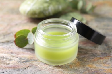 Jar of cream on textured table, closeup. Body care product