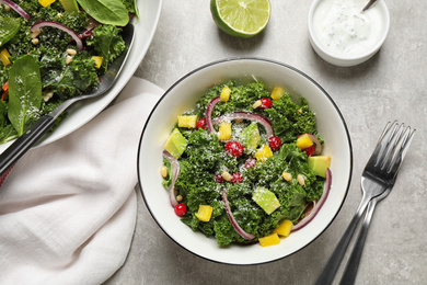 Photo of Tasty fresh kale salad on light grey table, flat lay