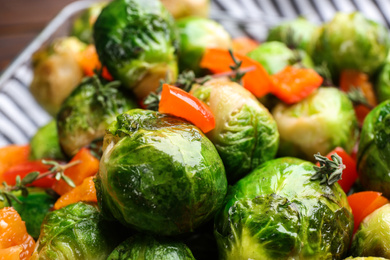 Photo of Delicious roasted Brussels sprouts with bell pepper as background, closeup