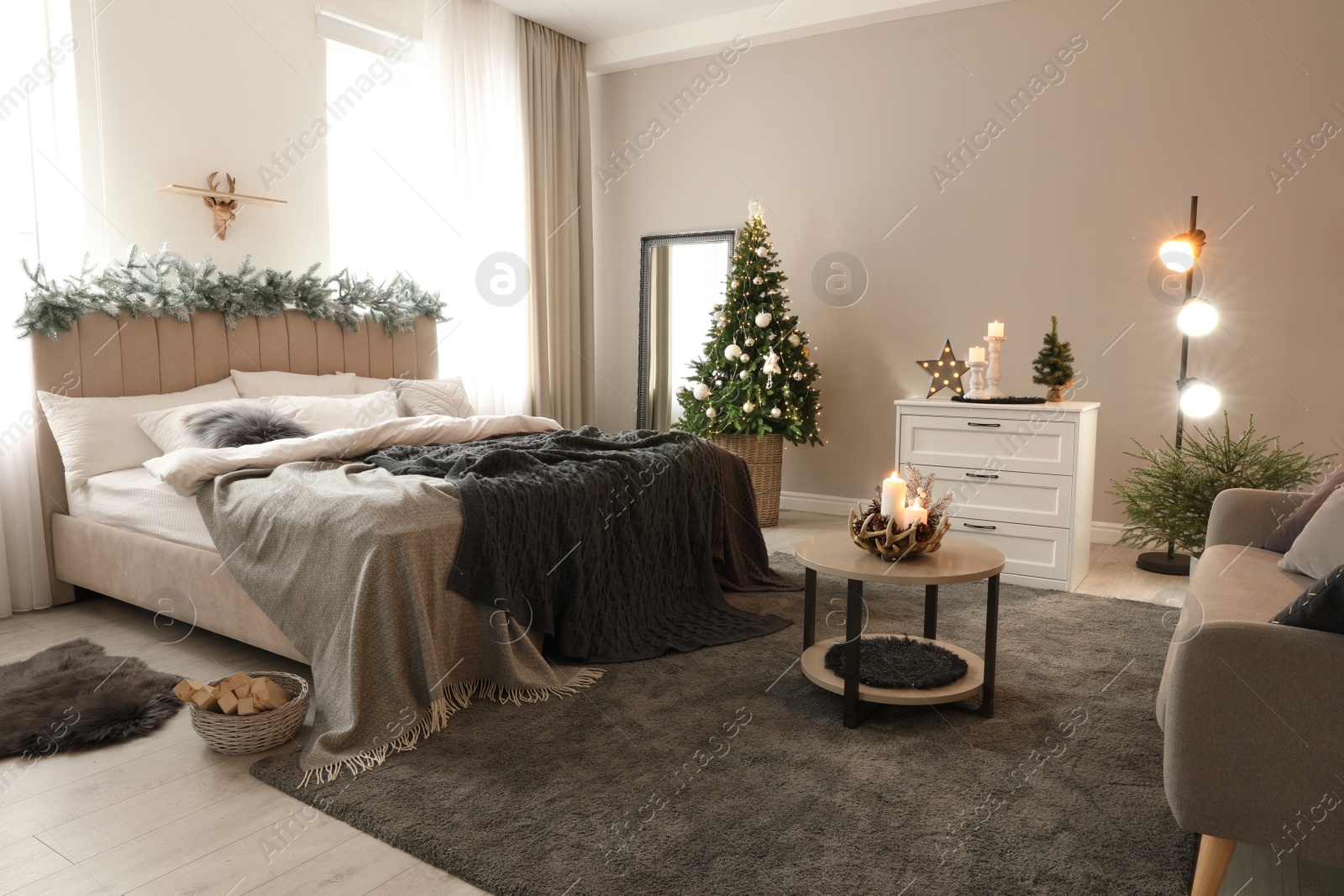 Photo of Beautiful decorated Christmas tree with fairy lights in bedroom interior