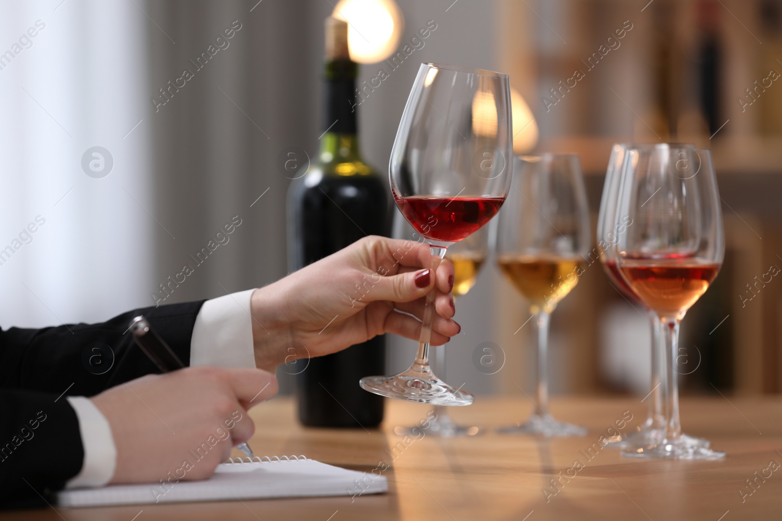 Photo of Sommelier tasting different sorts of wine at table indoors, closeup