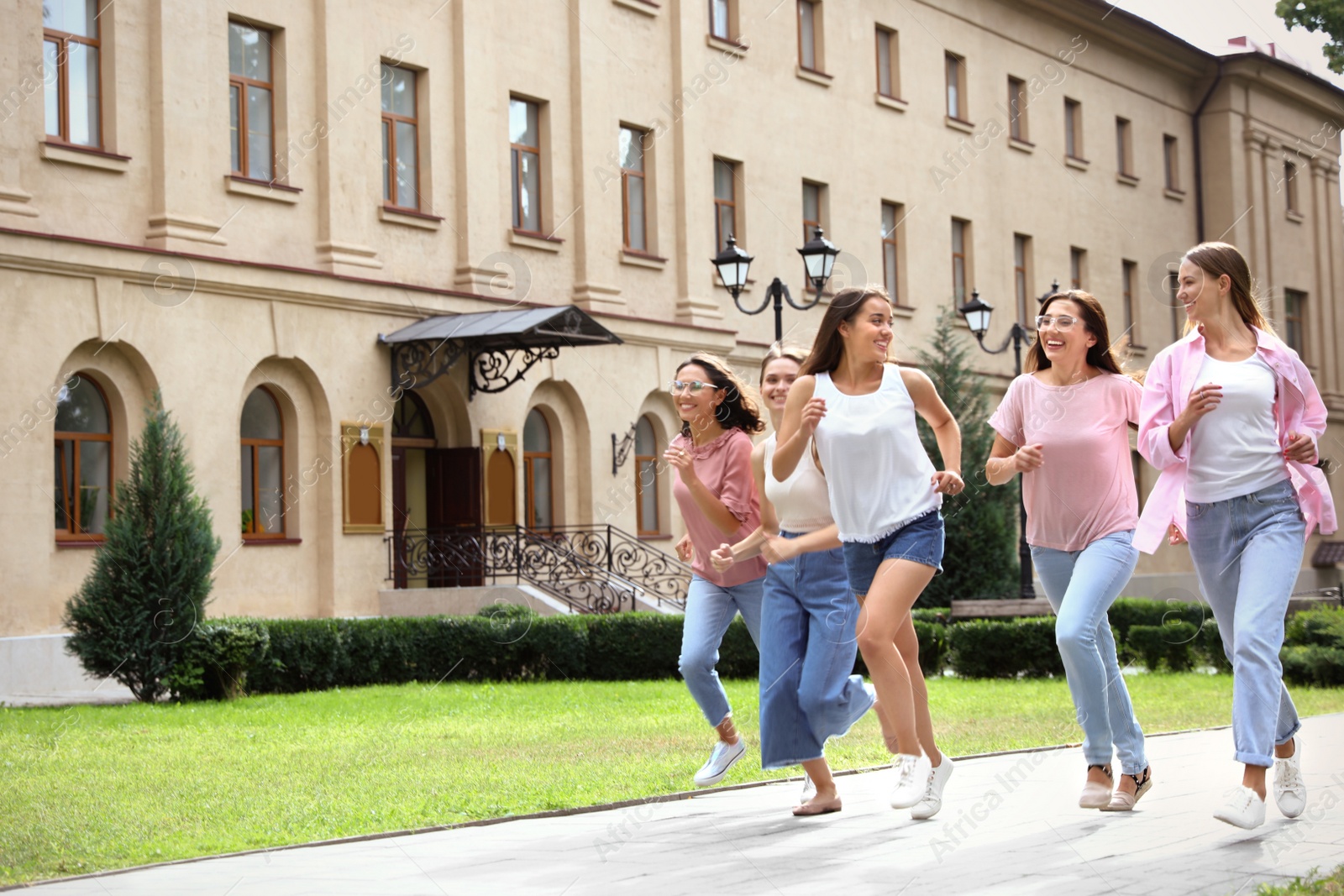 Photo of Happy women running outdoors on sunny day. Girl power concept