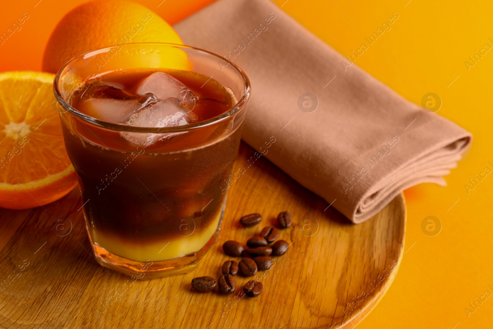 Photo of Tasty refreshing drink with coffee and orange juice on bright color background