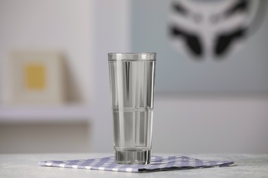 Glass of pure water on white table indoors