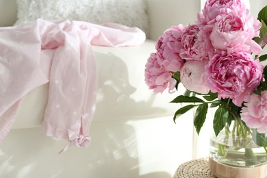 Photo of Bouquet of beautiful peonies on pouf indoors. Space for text