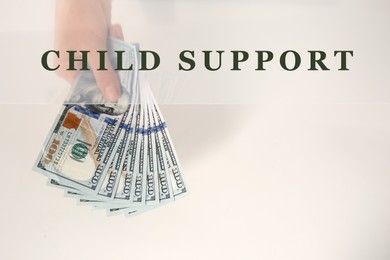 Image of Child support concept. Woman holding money on light background, top view