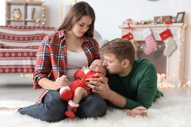 Photo of Happy couple with baby celebrating Christmas together at home