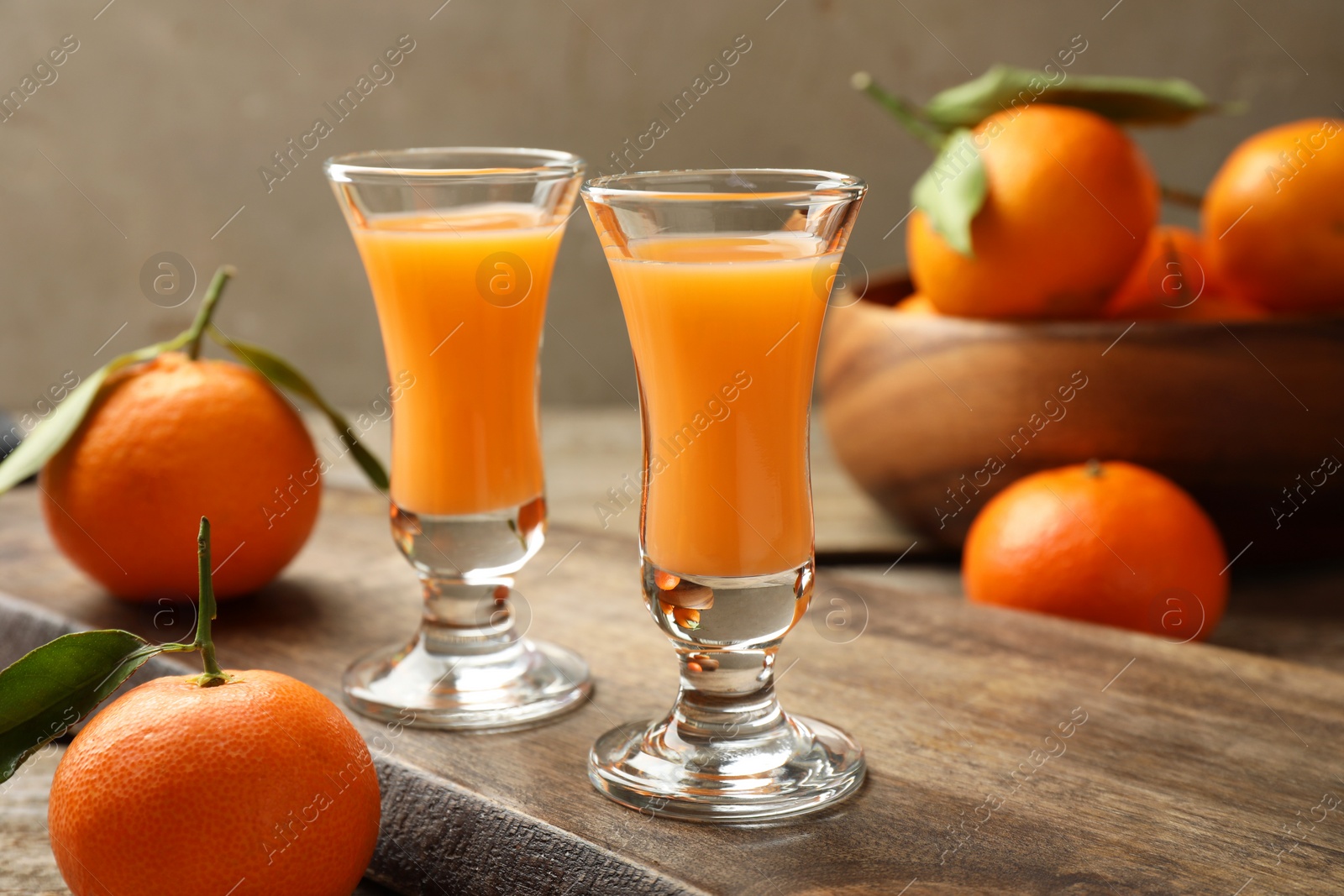 Photo of Delicious tangerine liqueur and fresh fruits on table