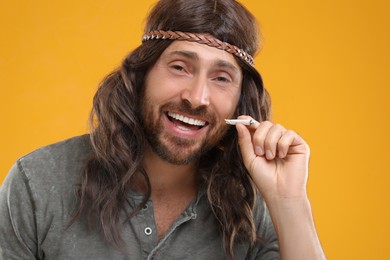 Photo of Hippie man with cigarette on orange background