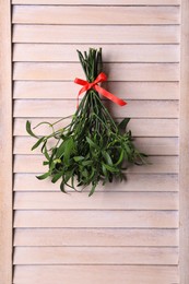 Photo of Mistletoe bunch with red bow hanging on wooden wall. Traditional Christmas decor