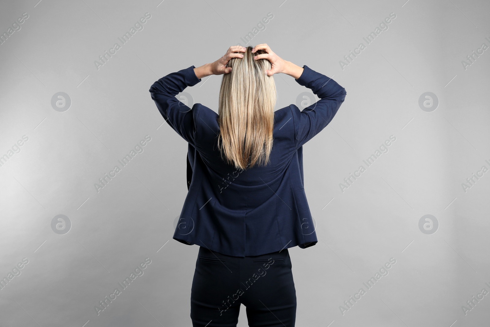 Photo of Young woman on grey background, back view