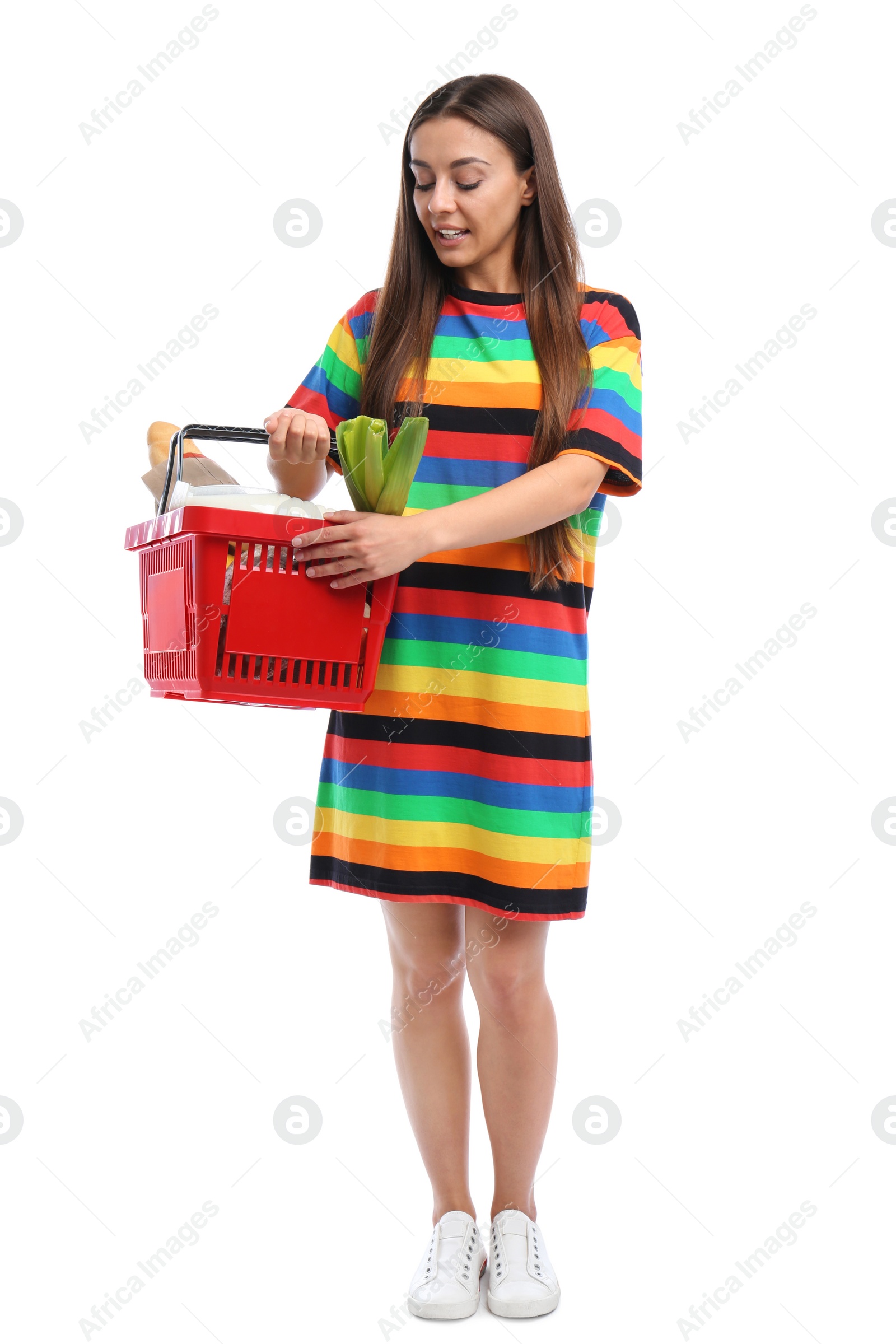 Photo of Young woman with shopping basket full of products isolated on white