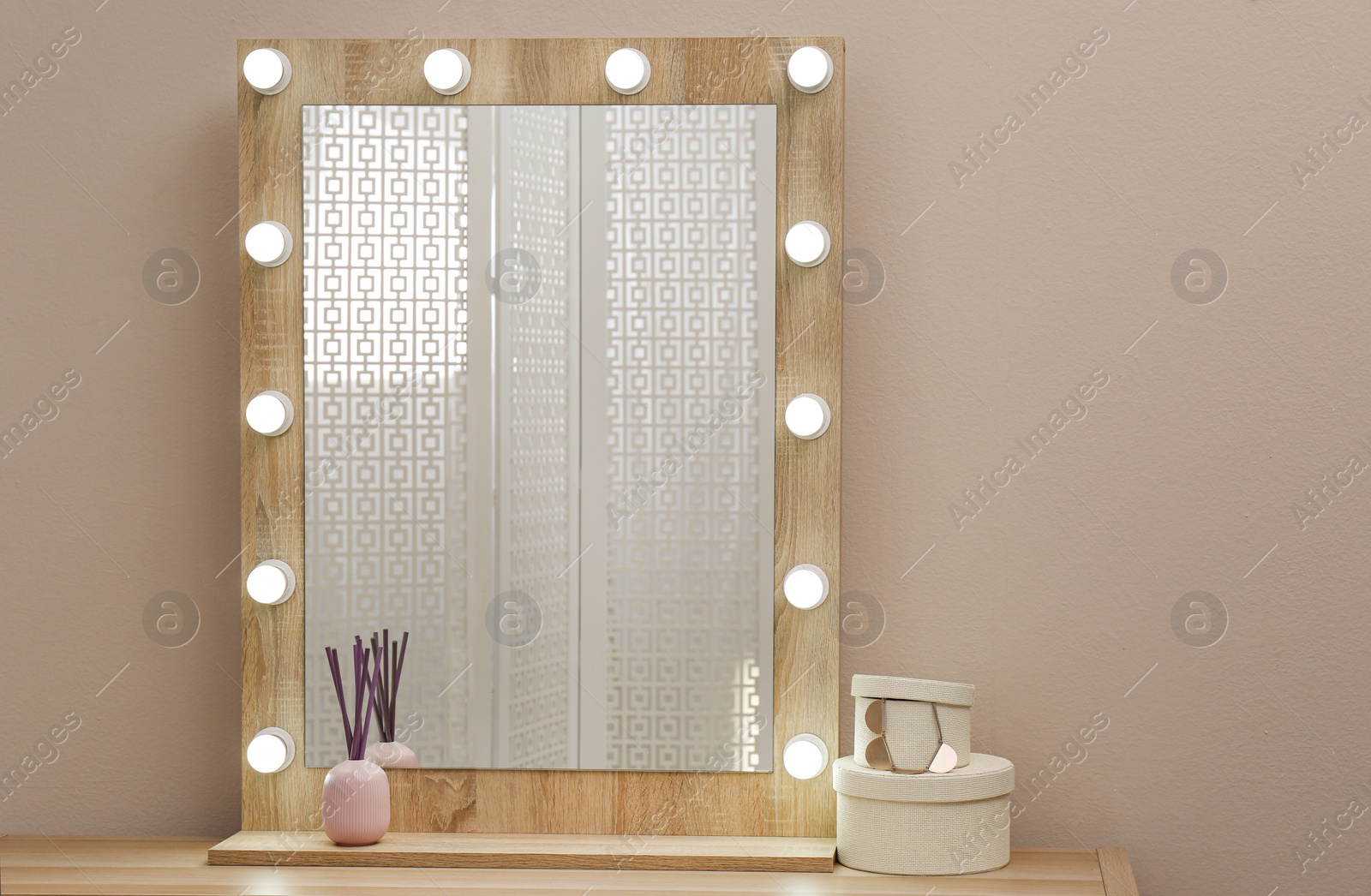 Photo of Stylish mirror with light bulbs near beige wall