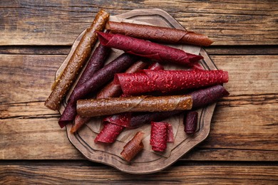 Photo of Delicious fruit leather rolls on wooden table, top view