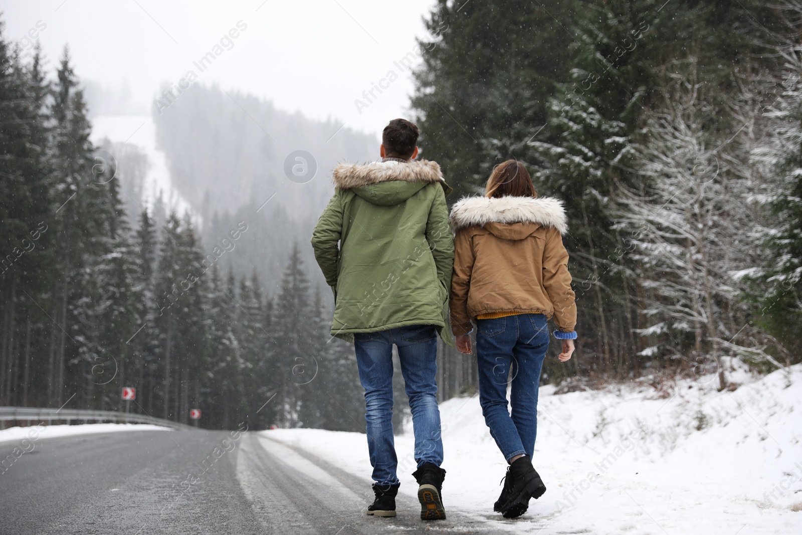 Photo of Couple walking near snowy forest. Winter vacation