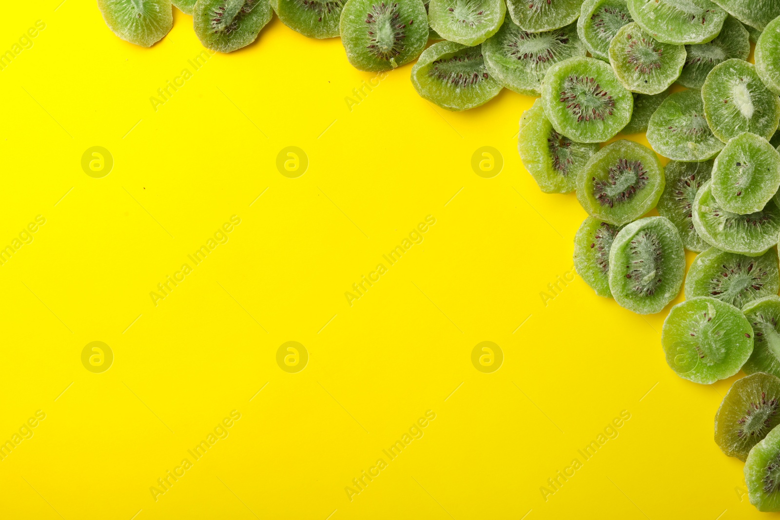 Photo of Frame made of kiwi on color background, top view with space for text. Dried fruit as healthy food