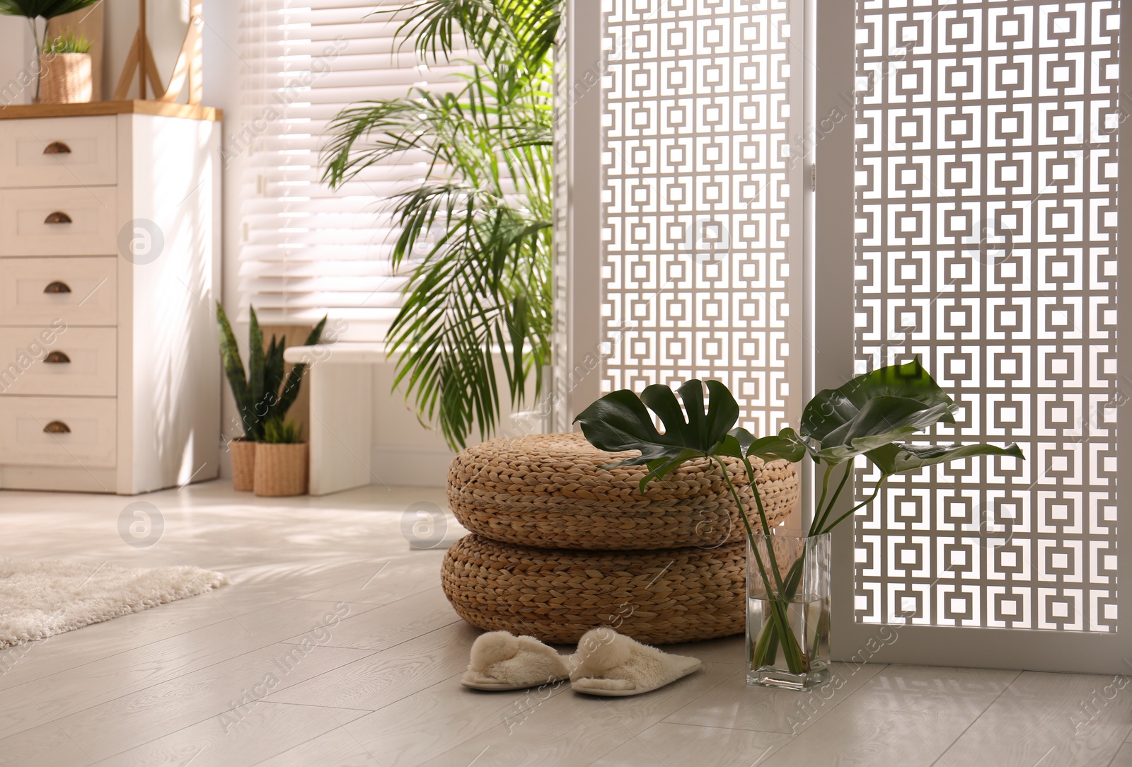 Photo of Stylish room interior with white folding screen and plants