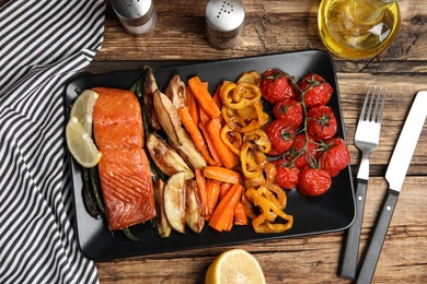 Photo of Tasty cooked salmon and vegetables served on wooden table, flat lay. Healthy meals from air fryer