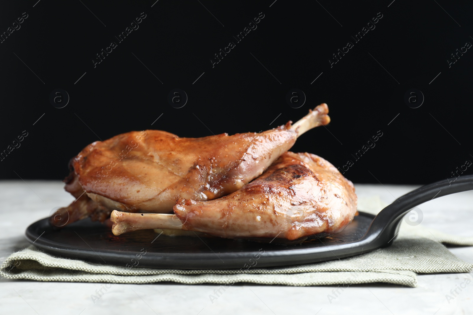 Photo of Tasty cooked rabbit meat on light grey table, closeup