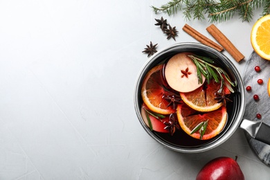 Saucepan with tasty mulled wine on grey background, flat lay. Space for text