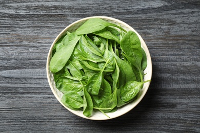 Photo of Fresh green healthy spinach on dark wooden table, top view