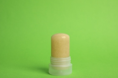 Photo of Natural crystal alum stick deodorant on green background