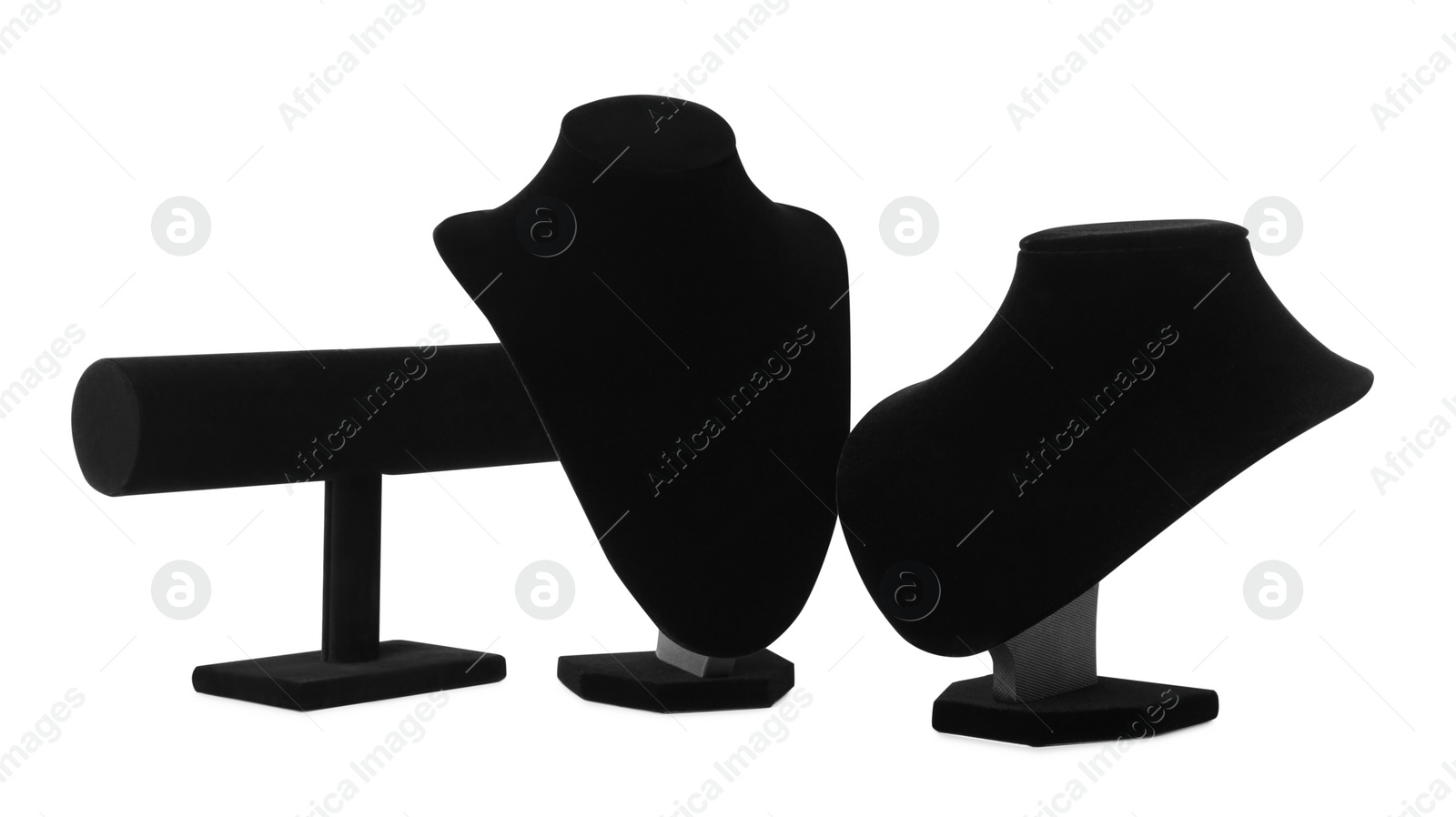 Photo of Different empty black velvet jewelry stands on white background