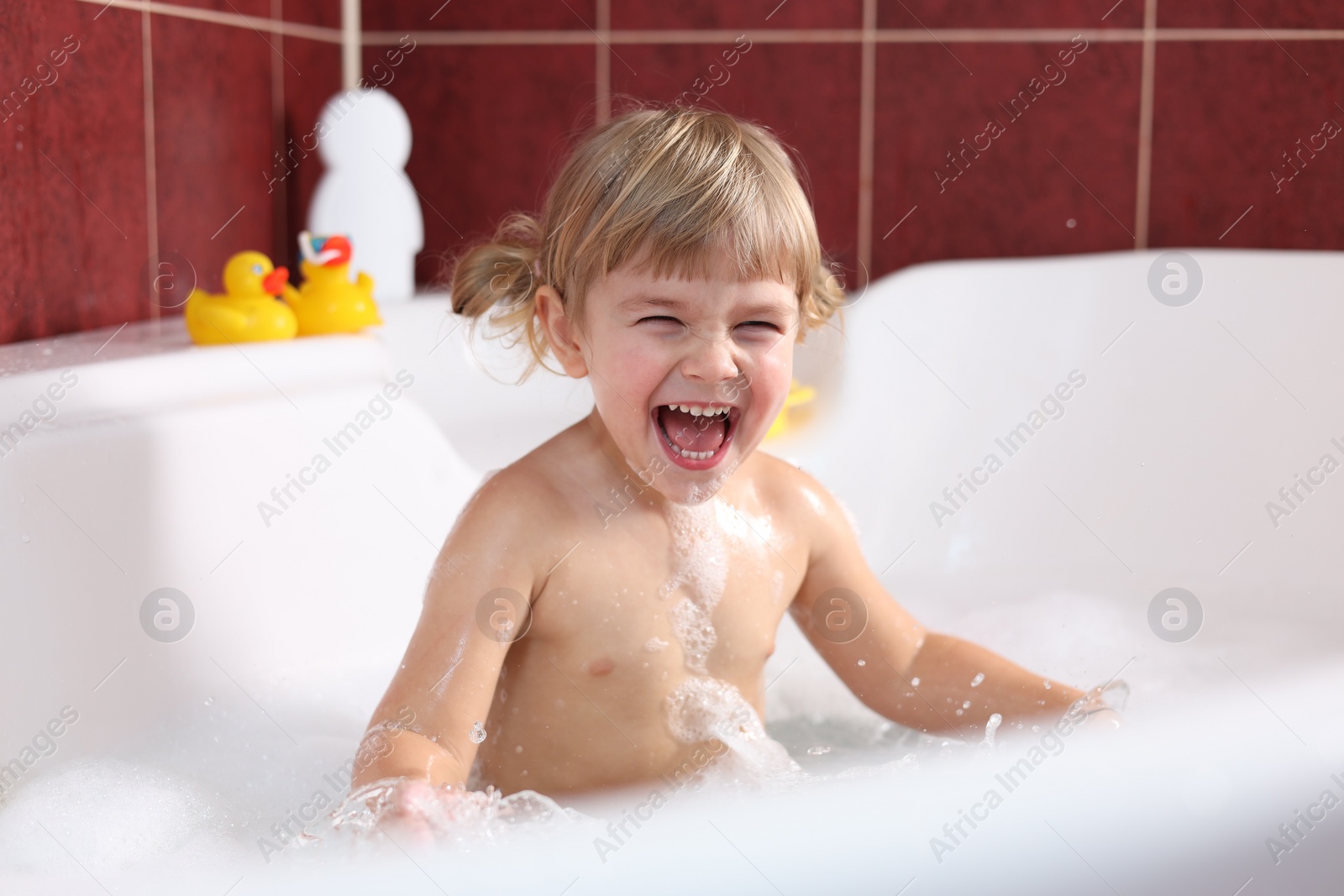 Photo of Happy girl bathing in tub at home