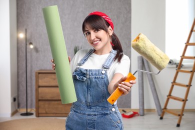 Image of Woman with wallpaper roll and roller in room