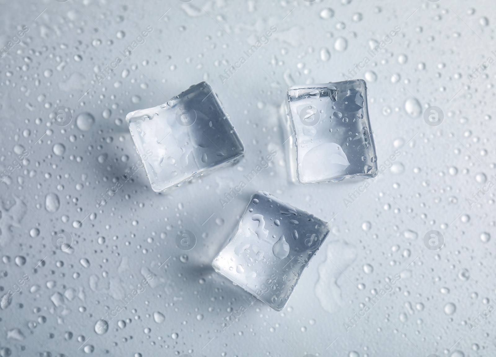 Photo of Ice cubes with water drops on white background, top view