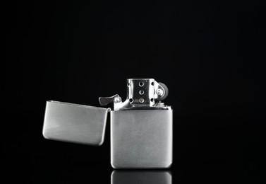 Gray metallic cigarette lighter on black background, closeup