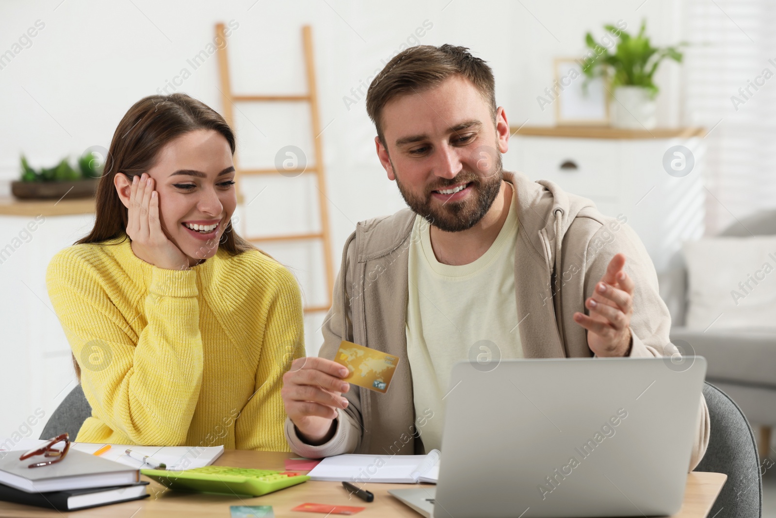 Photo of Young couple discussing family budget at table in living room