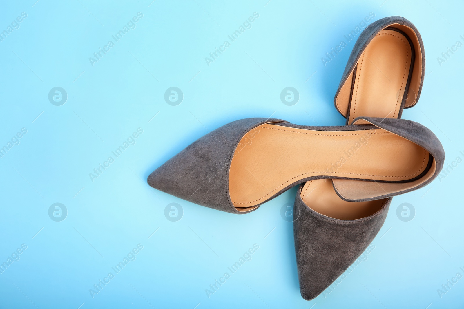 Photo of Pair of female shoes on color background