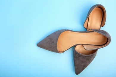 Pair of female shoes on color background