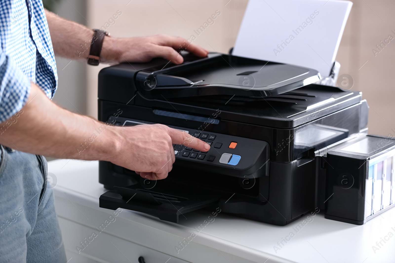 Photo of Employee using modern printer in office, closeup