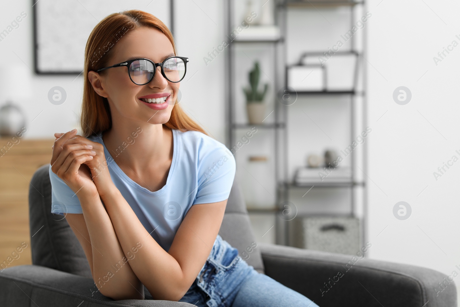 Photo of Portrait of beautiful smiling young woman. Happy lady with red hair at home. Space for text