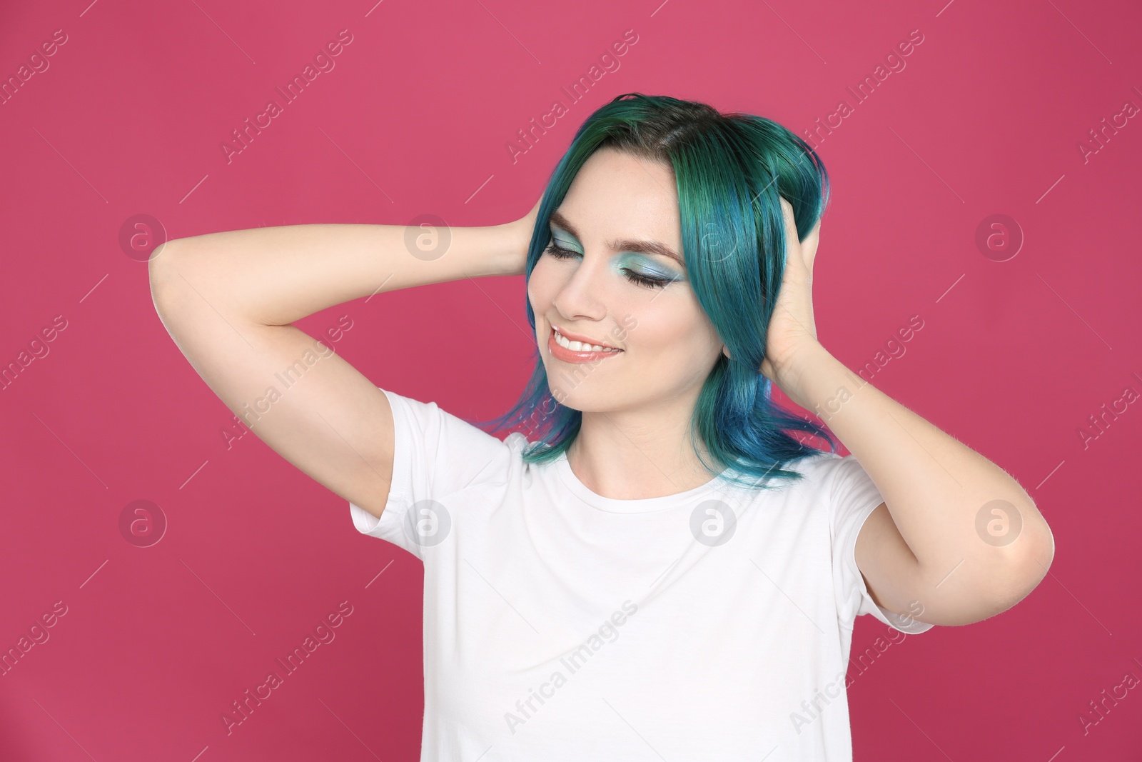 Photo of Young woman with bright dyed hair on pink background