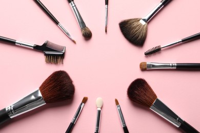 Photo of Frame of different makeup brushes on pink background, flat lay. Space for text