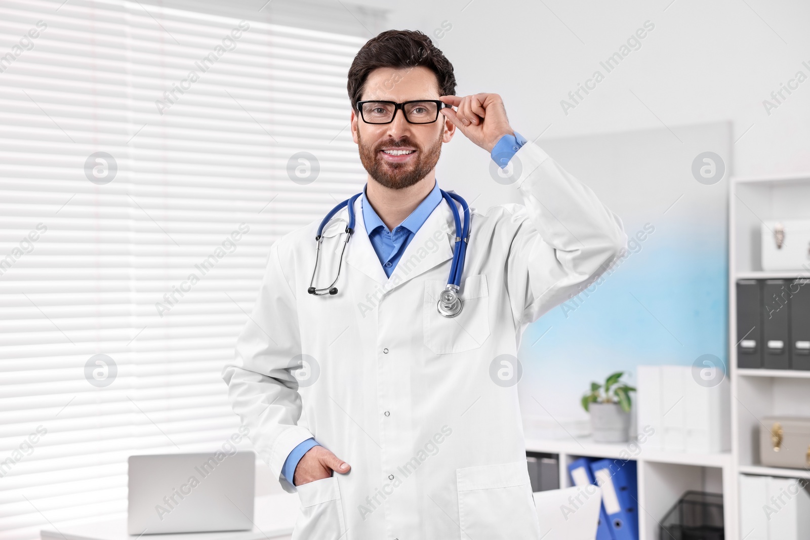 Photo of Medical consultant with glasses and stethoscope in clinic