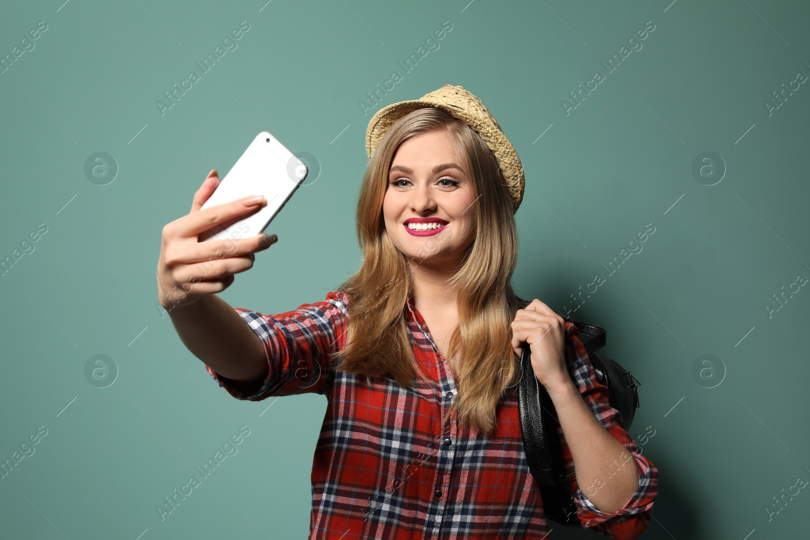 Photo of Attractive young woman taking selfie on color background