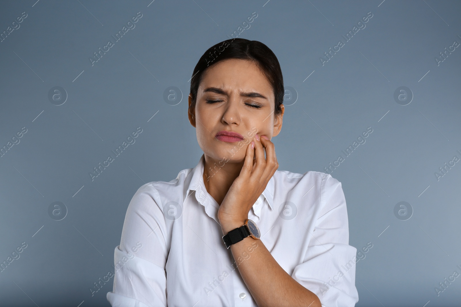 Photo of Woman suffering from toothache on grey background