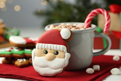 Tasty homemade Christmas cookie and hot chocolate with marshmallows on white table, closeup