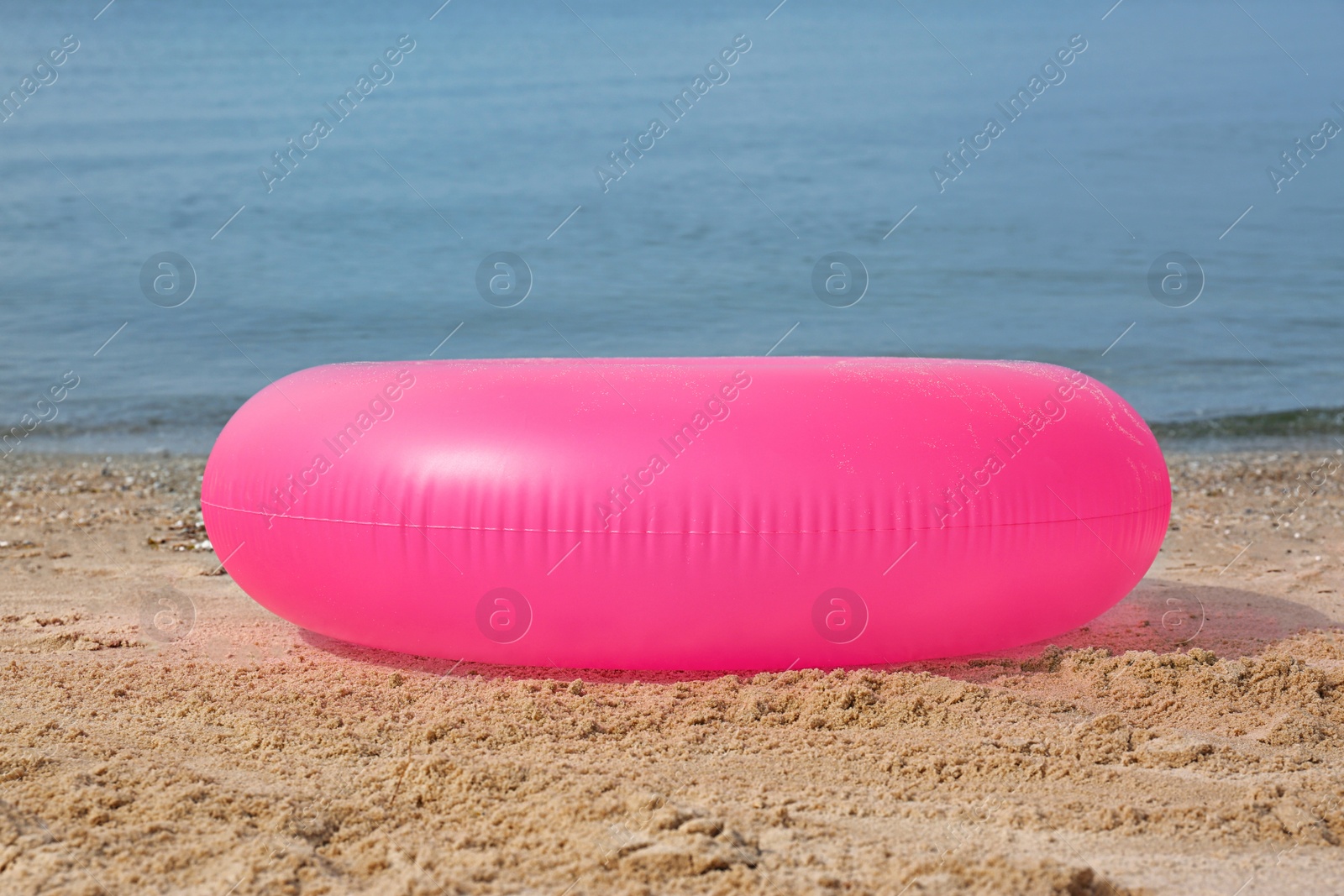 Photo of Bright inflatable ring near sea on sunny day