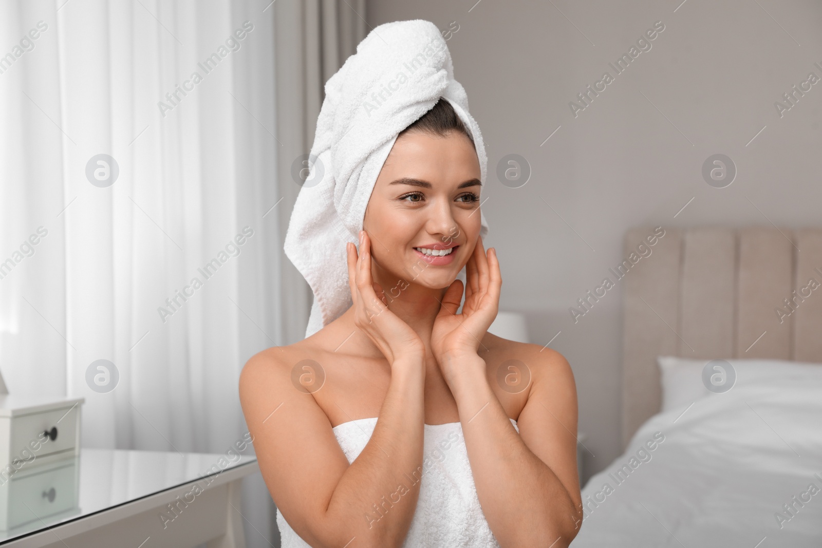 Photo of Beautiful young woman with hair wrapped in towel at home